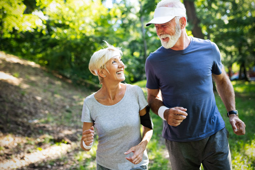 Mature couple jogging and running outdoors in nature